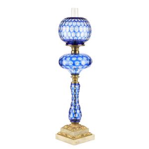 Cobalt cut overlay kerosene banquet stand lamp, made in America circa 1860-1880, 27 inches tall, cobalt blue cut to colorless pyriform font with ovals and punties (CA$50,150).