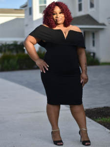 Yolanda Whitfield of Yolanda Financial Group posing in a black dress in front of her office