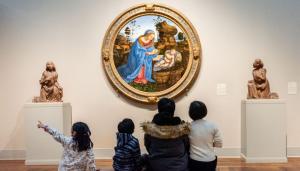 family sitting looking at painting at Toledo Museum of Art