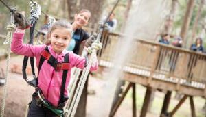 young girl smiling enjoying ropes course in Sports Coast