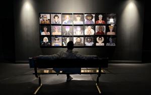 A black wall adorned with physical art frames, displaying digital artwork from House of Fashions digital collectibles, arranged in an art gallery style.