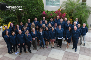 A group of Wicresoft employees wearing matching company jackets stands in a courtyard at their annual meeting.