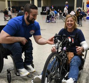 two individuals sitting in adaptive sports equipment talking