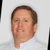 Photo of Ken McCallum, white man with dark brown hair in a white dress shirt