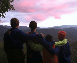 Trails Carolina Summer Mentorship Program students stand together on top of a mountain.