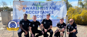 Gilbert Fire & Rescue team kneeling in front of Autism Acceptance Month sign