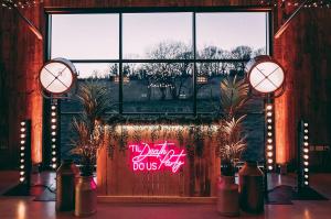 A custom rustic wooden DJ booth with vintage lighting setup in a wedding venue