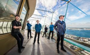 Various team members model the Space Needle uniforms on the observation deck.