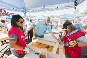 4 volunteers working on building a bed for children in need