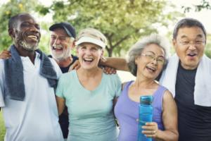 5 seniors smiling while exercising at the park
