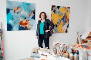 Abstract expressionism aesthetic paintings on canvas for home and office walls of contemporary informal artist Anja Stemmer in her studio. Colorful abstract painting XXL art on canvas for home and office