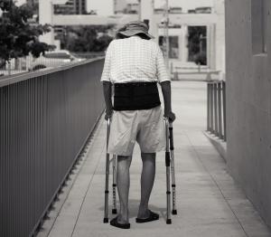 A picture of a knee surgery patient using a walker to start their rehabilitation process post-surgery.