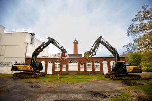 This photo shows the Wardenclyffe laboratory of Nikola Tesla alongside demolition equipment that will be used to remove non-historical buildings surrounding the lab.