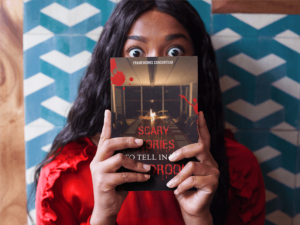 A woman holding the book Scary Stories to Tell in the Boardroom