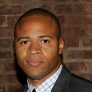 Man in suit against brick wall