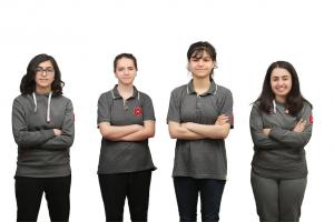 A group of four young women standing next to each other.