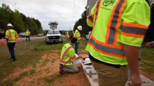 Photograph of engineers from Point Broadband laying fiber in Macon County, Alabama