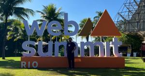 Sam Johnston standing in front of the Web Summit Rio sign at Riocentro, Rio de Janeiro
