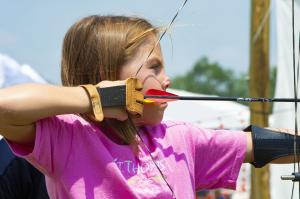 Female Scout preparing to shoot on the archery range