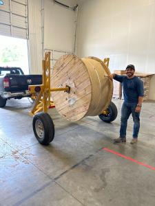 Photograph of Juan Castilla, Hawk Networks Construction Manager in Atlanta, with reel of fiber.