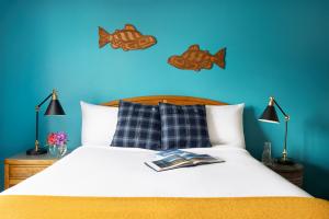 Picture of a typical guest room at The Ketch, in Ketchikan, Alaska. The new interior scheme by artist and designer Henry Chebaane, featuring teal blue, burnt orange, indigenous art, flannel cushions by Carhartt