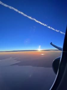 Image of an aircraft contrail viewed from a different aircraft at sunset