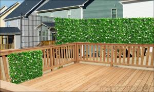 A metal fence mounts on top of the deck railing and faux leaves are attached