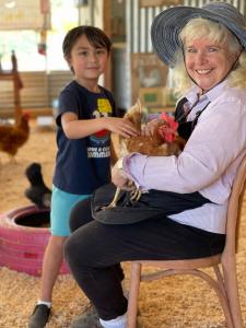 A child visiting and learning about chickens during a Chicks & Sprouts Educational workshop at the Tanaka Farms Barnyard Educational Exhibit.