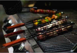 A grilling basket filled with vegetables on a grill.