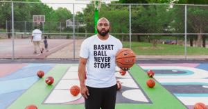 Jahi Rawlings, CEO Finish First Marketing Agency and Founder of the AEBL, a pro-am basketball league is holding a basketball on a colorful basketball court with basketballs scatter but placed to add texture and meaning.