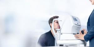 Man that gets his eyes measured with a ZEISS VISUREF 150 autofraction machine.