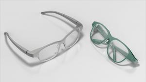 Two "ESSNZ SLIM" smart glasses in green and grey laying on a white surface.