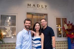 The 3 MADLY partners are standing in front of the MADLY brand experience store in Ann Siang Road, Singapore. The photo depicts Chief Growth Officer Victor Saint-Pere, a curly haired, bearded French man, Founder Maddy Barber, a petite Singaporean-Chinese l