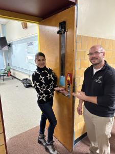 Founder Anna Reger and a ROE 47 representative showing a school door with Flip Lok installed