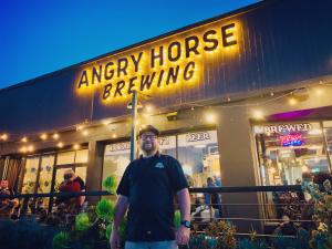 Nathan McCusker, President and Co-Founder of Angry Horse Brewing, pauses for a photo outside the brewery during the AHB 6th Anniversary Event