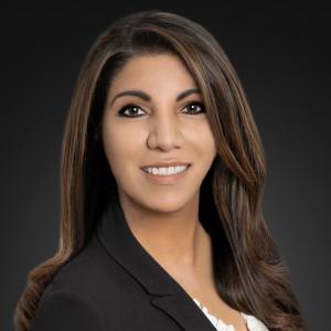 Headshot of a woman with brown hair who is smiling and wearing a white shirt and black blazer. The woman in the photo is Dilanthi De Alwis-Mummert, Chief Financial Officer, TRAFFIX.
