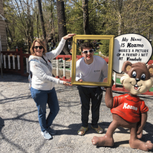 mom and son enjoying trip to Knoebels and taking photo in self stand at the park
