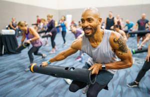 Man at a fitness conference using a Vipr and having fun in a session.