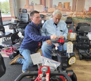 Picture of Franchise Owner Don Guilbert helping a customer with a mobility scooter in his Columbus OH showroom