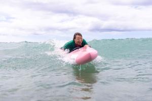 Female adaptive athlete paddleboarding in the ocean surf