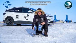 Rainer Zietlow stands in front of an electric vehicle with FUCHS BluEV in snowy Deadhorse, Alaska