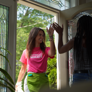 A Better Life Maids team member is welcomed into a clients home. The client high fives the team member.