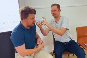 Two men practicing asthma first aid skills.