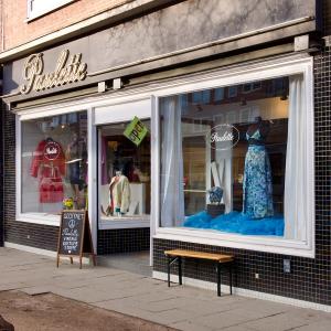 Exterior view of Aventures de Paulette, a leading secondhand shop in Hamburg, featuring vintage fashion displays in the storefront windows."