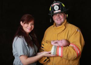 Nurse and firefighter with newborn safely in their arms.