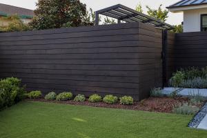 beautiful planting in front of entry way black fence