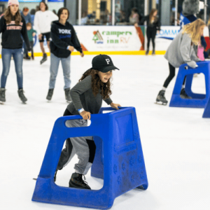 young girl on the ice at Community First Igloo using balancer for skating