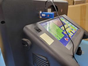 A GRIDBluFly adapter connected to the serial data port of a scoreboard display for remote access via Bluetooth.