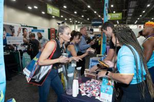 A woman talks to a vendor about a fitness product at the IDEA World Expo