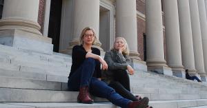 Two women sitting on the steps of Harvard University's Widener Memorial Library.